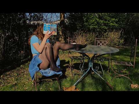 A girl in pantyhose reading in the garden